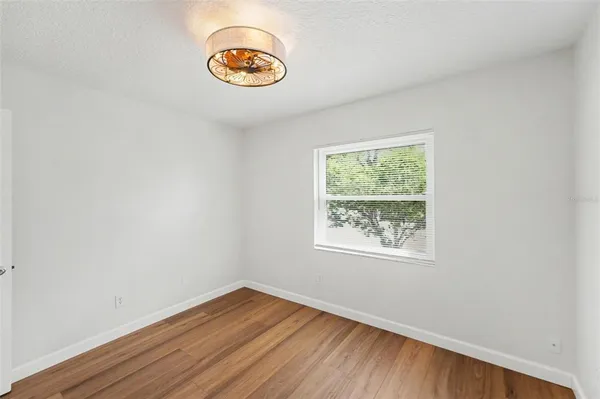 an empty room with wooden floor and window