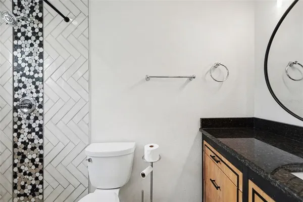 a bathroom with a granite countertop sink toilet and shower