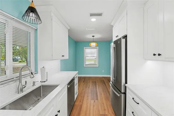 a kitchen with granite countertop a sink stainless steel appliances and cabinets