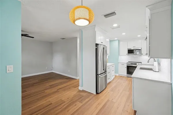 a kitchen with a refrigerator sink and cabinets