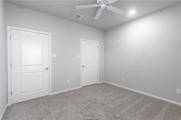 an empty room with a ceiling fan and a window