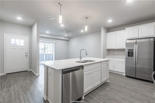 a kitchen with a sink window and refrigerator