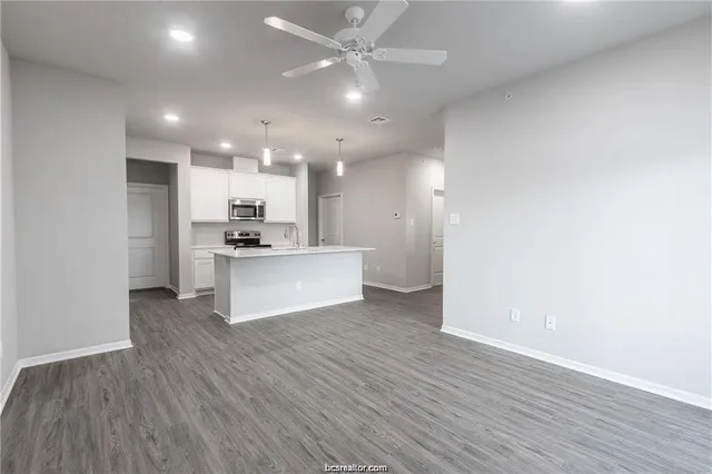 a view of kitchen with granite countertop cabinets and refrigerator