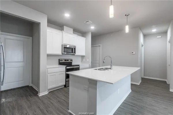 a kitchen with sink a microwave and refrigerator