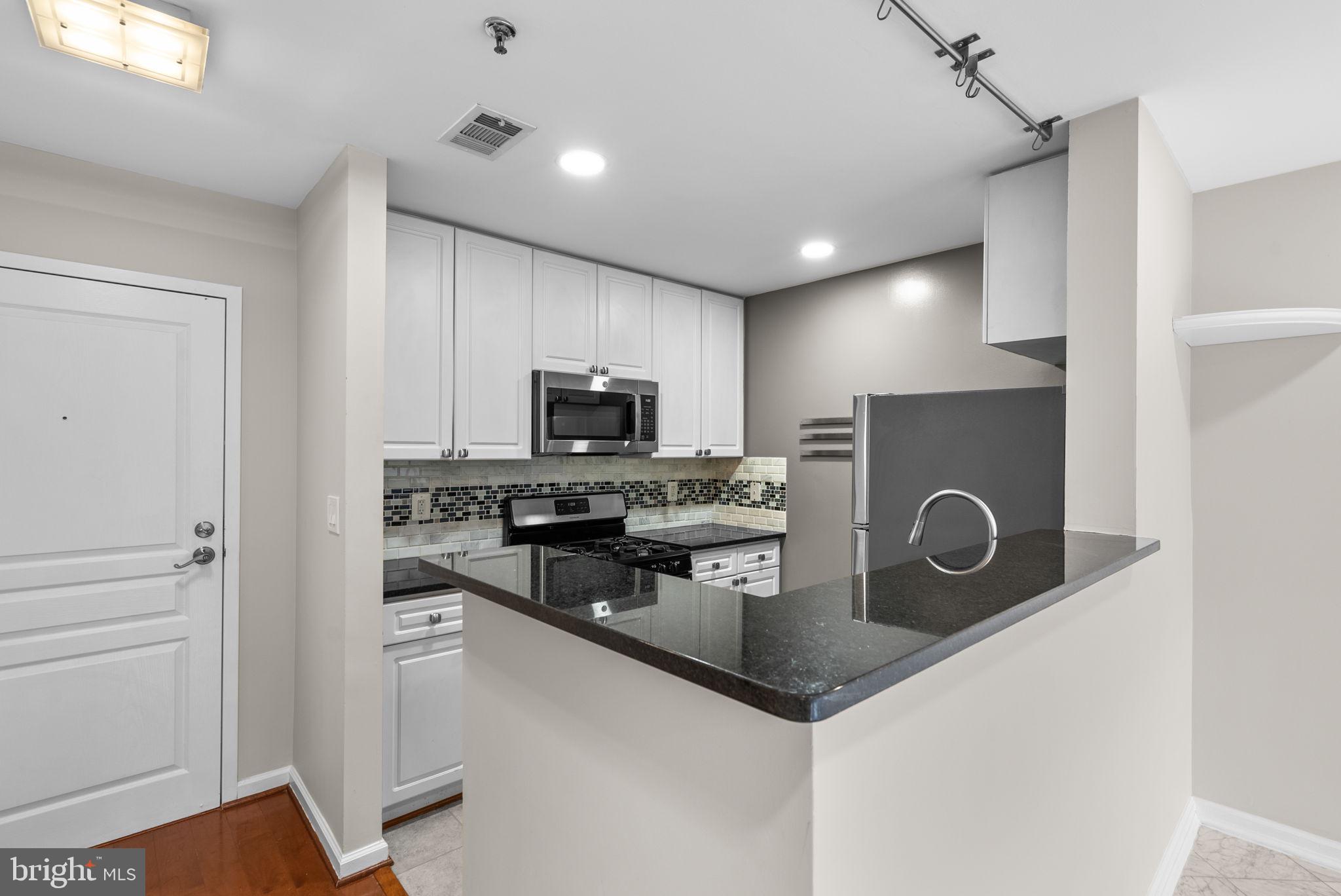 5563 Seminary Road, Unit 302 Falls Church, VA 22041 - Photo 12 of 30 a kitchen with stainless steel appliances granite countertop a refrigerator a stove a sink and a microwave