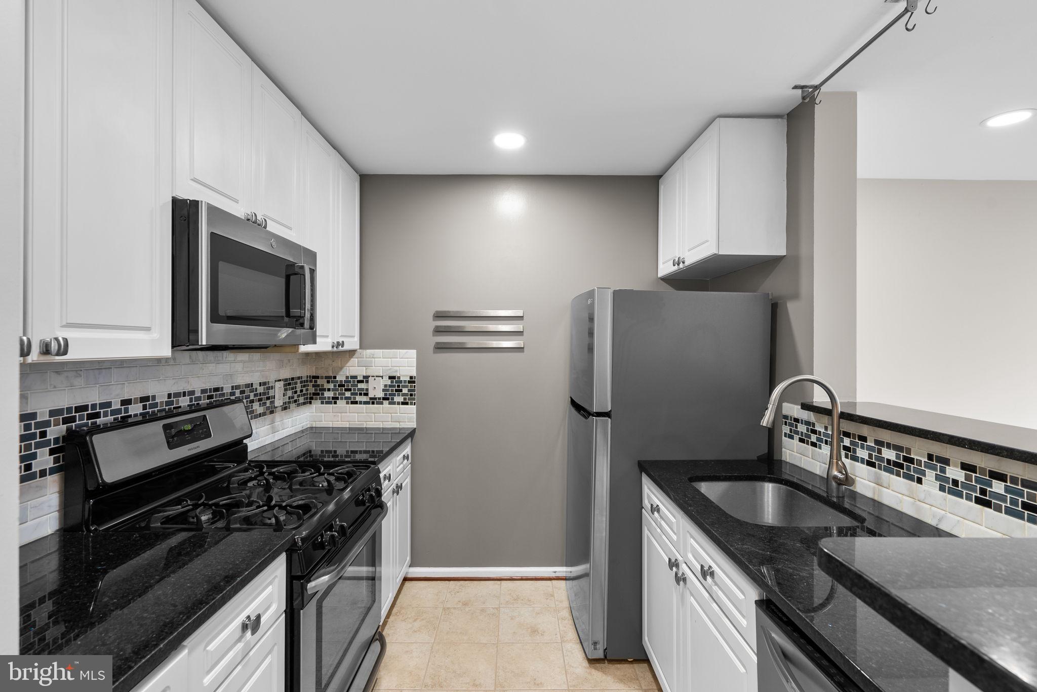 5563 Seminary Road, Unit 302 Falls Church, VA 22041 - Photo 13 of 30 a kitchen with stainless steel appliances granite countertop a sink stove and refrigerator