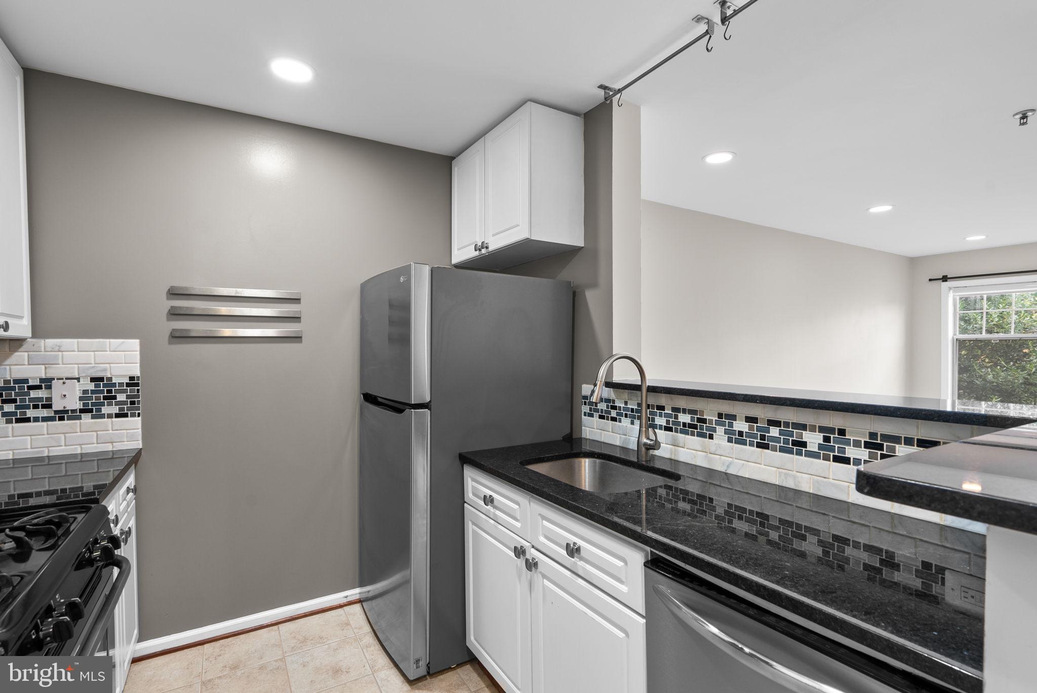 5563 Seminary Road, Unit 302 Falls Church, VA 22041 - Photo 14 of 30 a kitchen with granite countertop a stove and a refrigerator