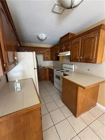 a kitchen with stainless steel appliances granite countertop a sink counter space cabinets and a stove top oven