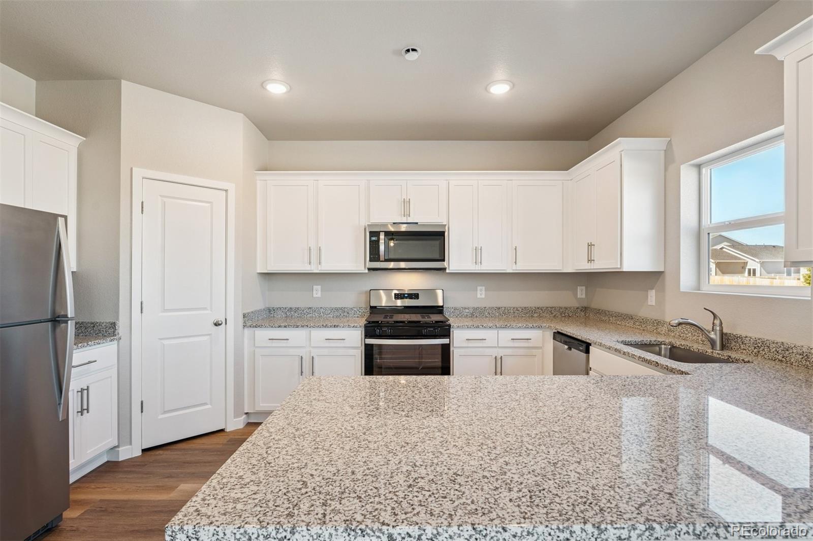 2125 Alyssa Street Fort Lupton, CO 80621 - Photo 3 of 39 a kitchen with a refrigerator stove and sink