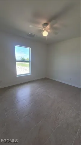 an empty room with a ceiling fan and carpet