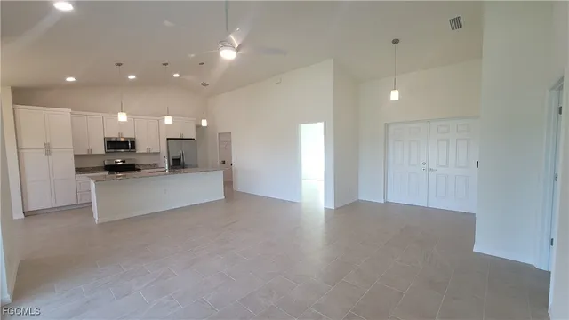 a view of kitchen with kitchen island and stainless steel appliances
