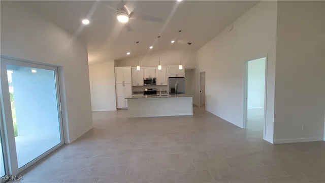 a view of a living room a kitchen and a kitchen with a sink