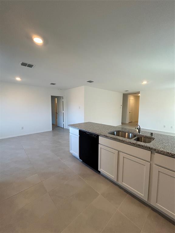 2813 Watchpoint Road Little Elm, TX 75068 - Photo 8 of 8 Kitchen featuring black dishwasher, light stone counters, recessed lighting, open floor plan, and white cabinets