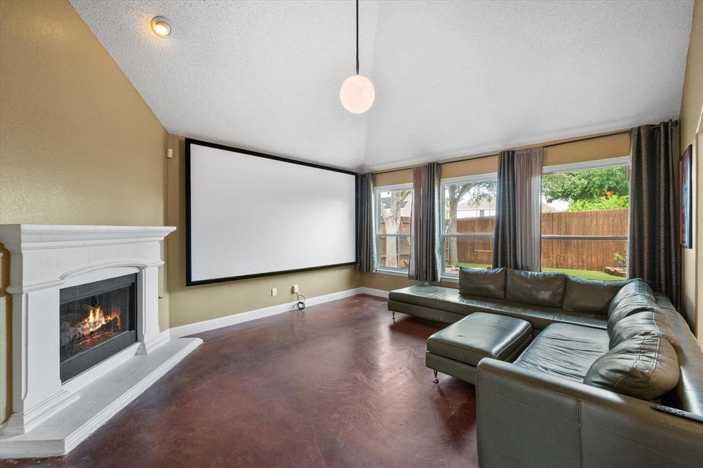 1305 Liverpool Lane Mansfield, TX 76063 - Photo 11 of 40 Living area featuring a fireplace, a projection screen, and windows with outdoor views