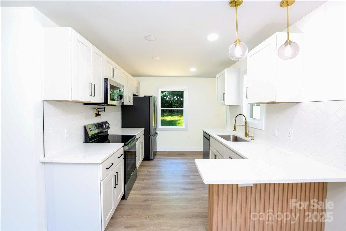 2918 Lon Street Shelby, NC 28152 - Photo 7 of 17 a kitchen with a sink a counter top space stainless steel appliances and a window