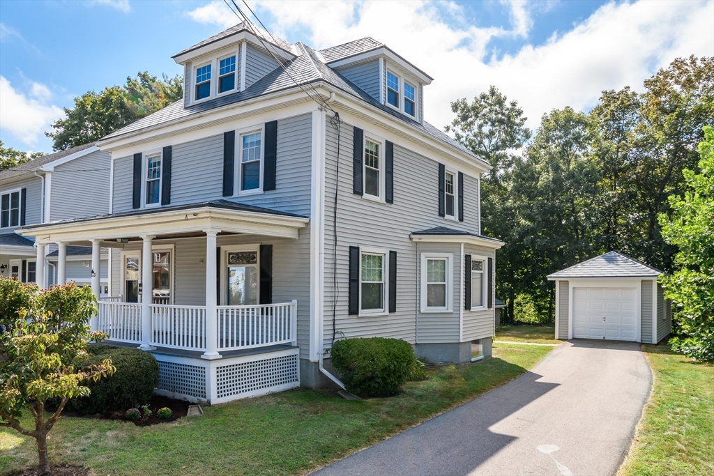 a front view of a house with a yard and trees