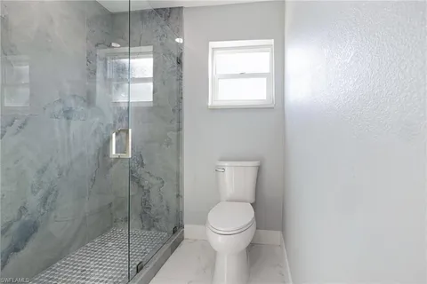 a bathroom with a toilet and a shower