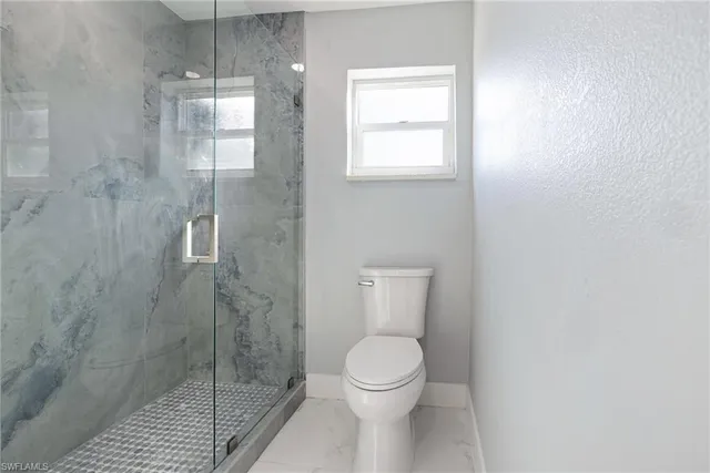 a bathroom with a toilet and a shower