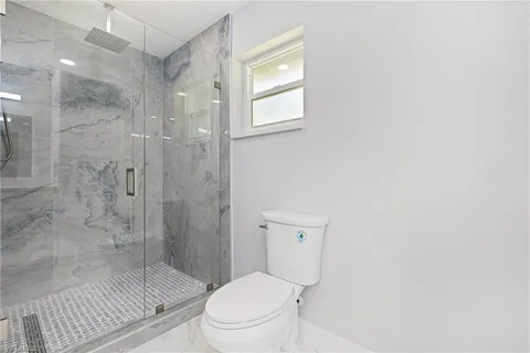a bathroom with a toilet a sink and shower