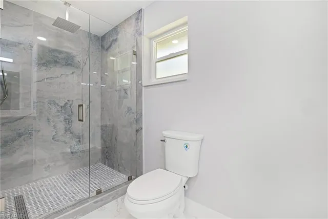 a bathroom with a toilet a sink and shower