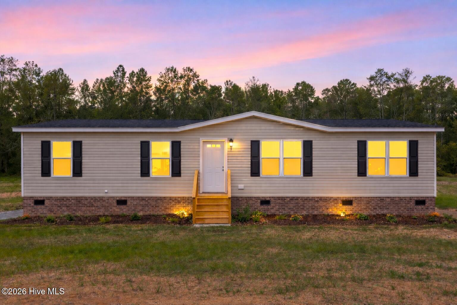 1755 Lynch Road Hollister, NC 27844 - Photo 1 of 35 Twilight glow on cozy home