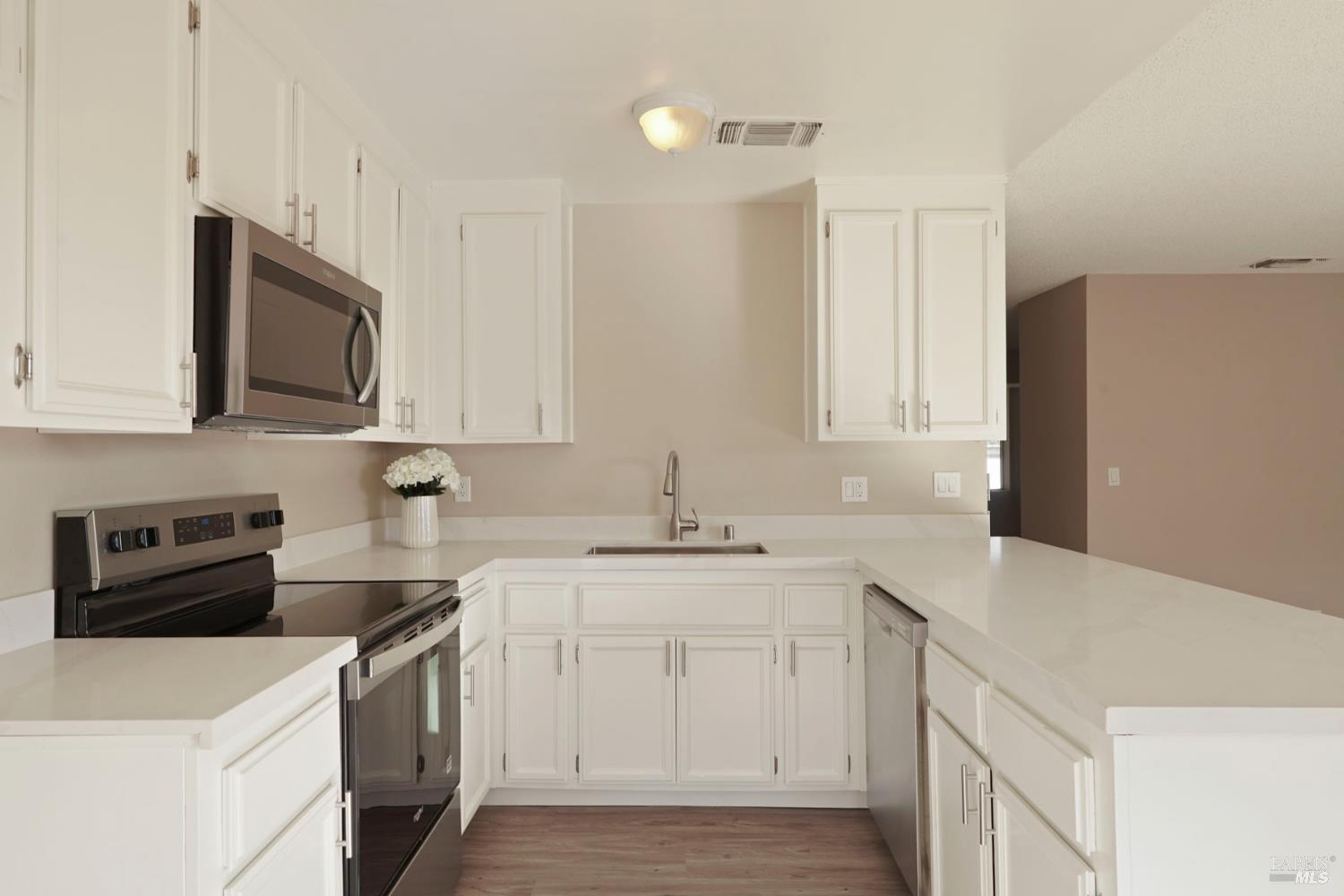 28 Amador Circle Rio Vista, CA 94571 - Photo 4 of 39 a kitchen with a sink dishwasher stove and white cabinets