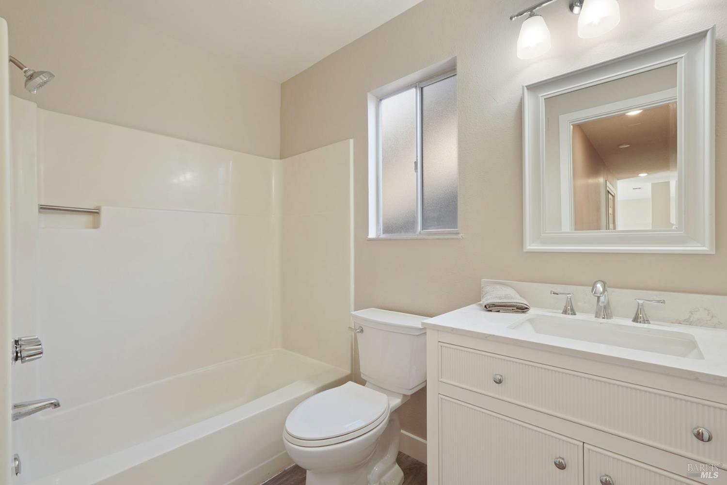 28 Amador Circle Rio Vista, CA 94571 - Photo 6 of 39 a bathroom with a toilet a sink a mirror a bathtub and shower
