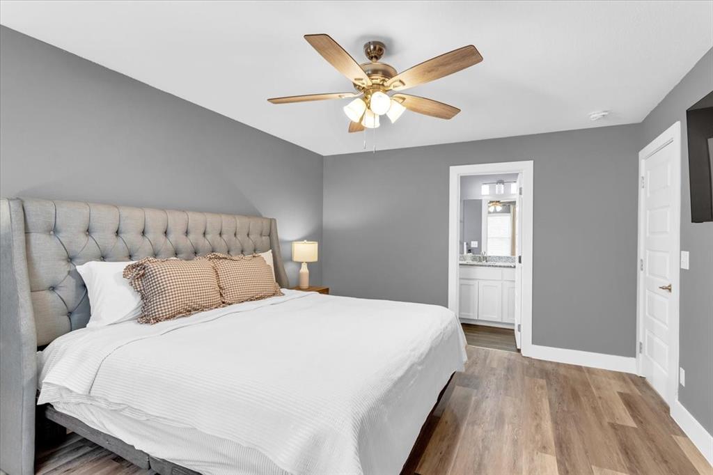 312 East Day Street Denison, TX 75021 - Photo 11 of 24 a bedroom with a large bed and a chandelier