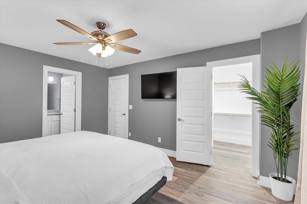 312 East Day Street Denison, TX 75021 - Photo 12 of 24 a bedroom with a large bed and a chandelier