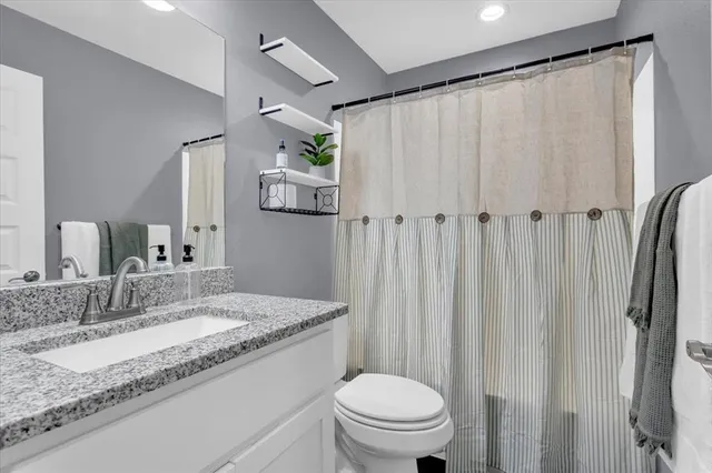 a bedroom with a bed and a lamp on dresser