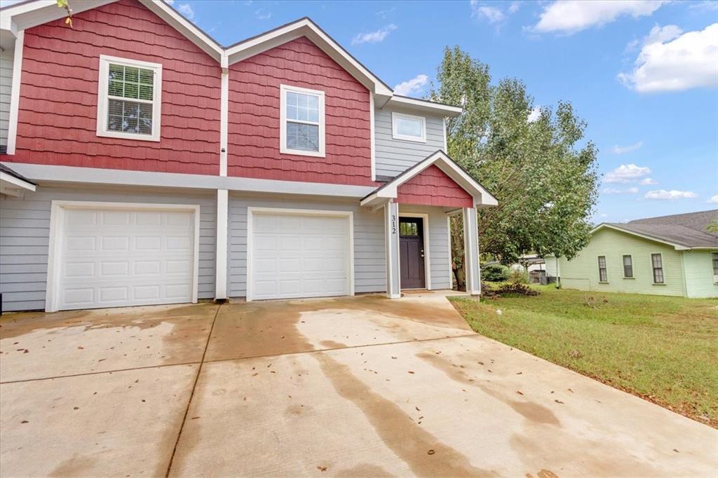 312 East Day Street Denison, TX 75021 - Photo 20 of 24 a front view of a house with a yard and garage
