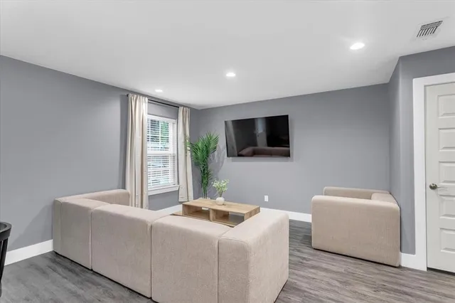 a living room with stainless steel appliances furniture a refrigerator and a view of kitchen