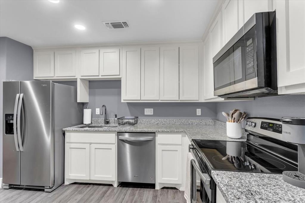 312 East Day Street Denison, TX 75021 - Photo 6 of 24 a kitchen with stainless steel appliances granite countertop a refrigerator sink and stove