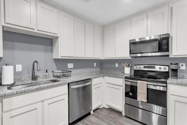 a kitchen with stainless steel appliances granite countertop a refrigerator sink and stove