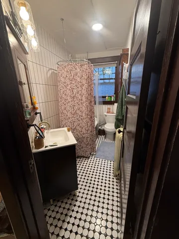 a bathroom with a sink a toilet a mirror and shower