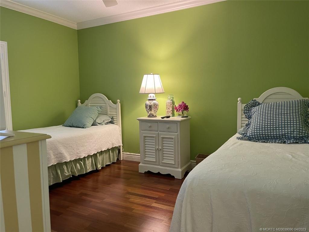 144 Northeast Edgewater Drive, Unit 3102 Stuart, FL 34996 - Photo 15 of 23 a bedroom with a bed and wooden floor