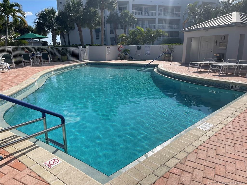 144 Northeast Edgewater Drive, Unit 3102 Stuart, FL 34996 - Photo 20 of 23 a backyard of a house with table and chairs