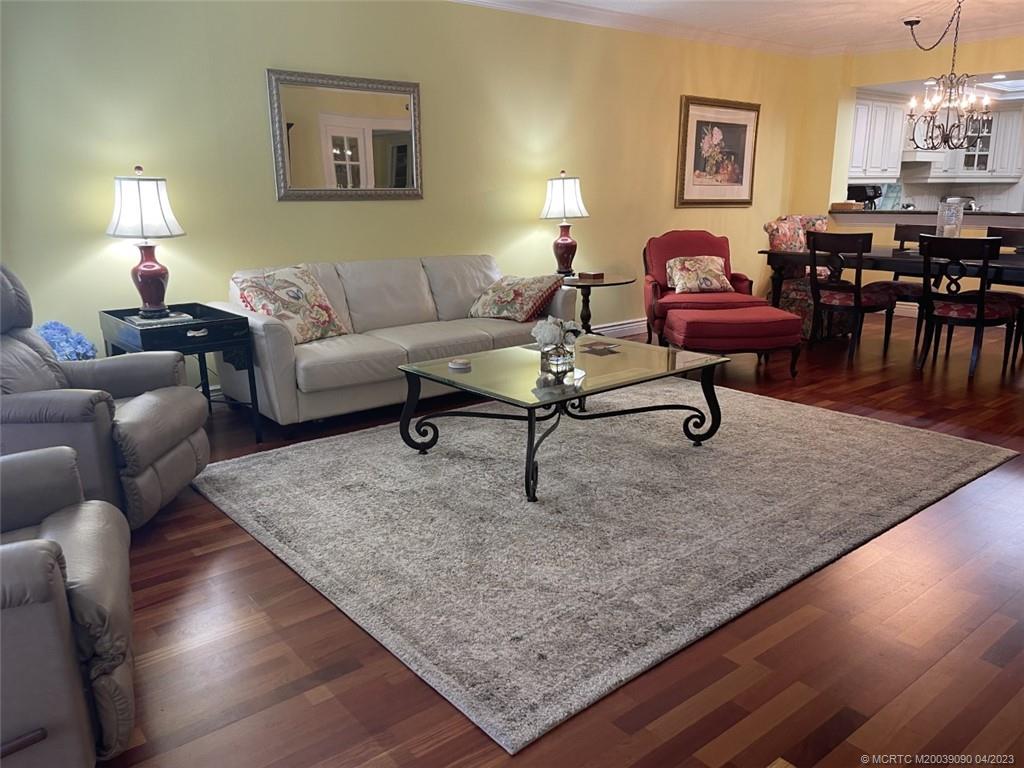 144 Northeast Edgewater Drive, Unit 3102 Stuart, FL 34996 - Photo 7 of 23 a living room with furniture and a lamp