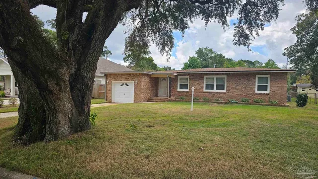a view of a house with backyard and garden