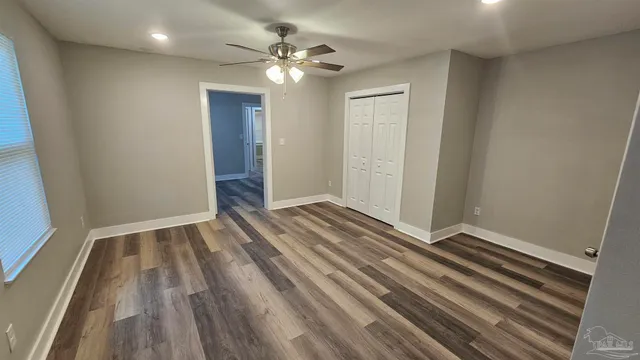 a view of an empty room with wooden floor