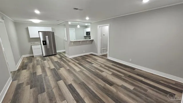 a view of empty room with wooden floor