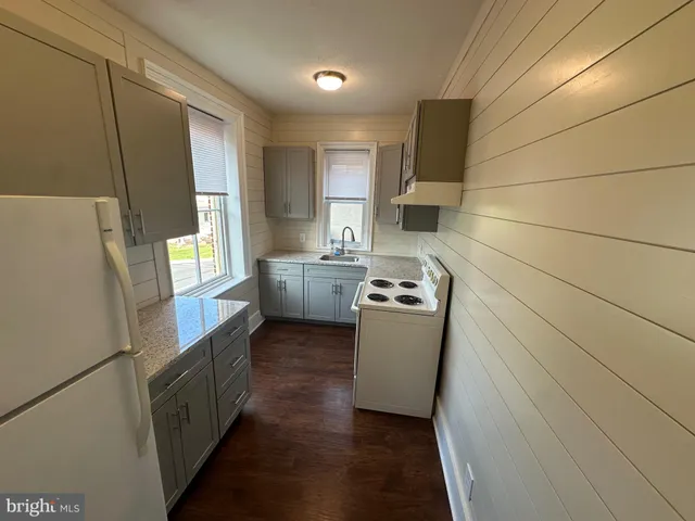 a view of kitchen with window and refrigerator