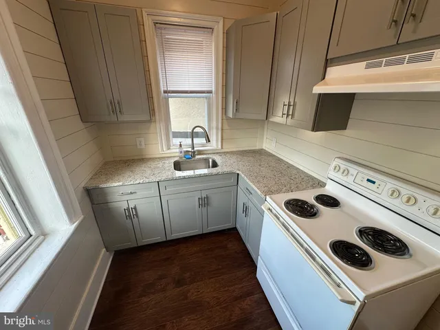 a kitchen with a stove sink and cabinets