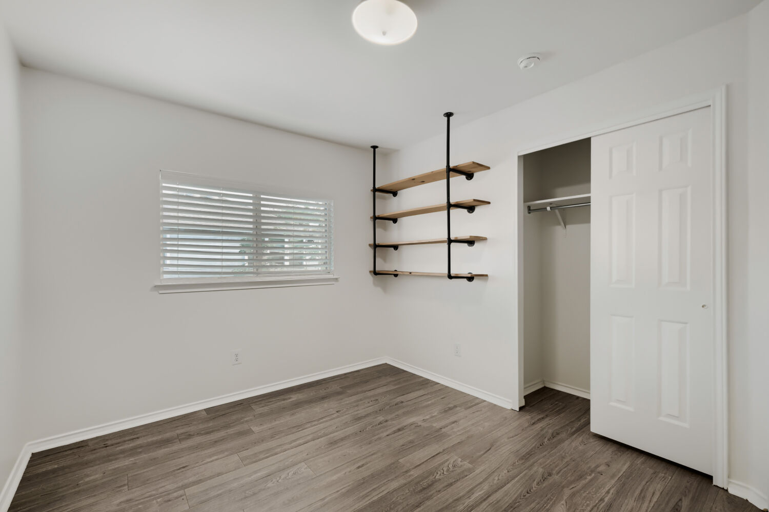 4508 Peach Grove Road Austin, TX 78744 - Photo 17 of 22 Wood-look flooring complements the crisp white walls and convenient closet storage in this versatile room.