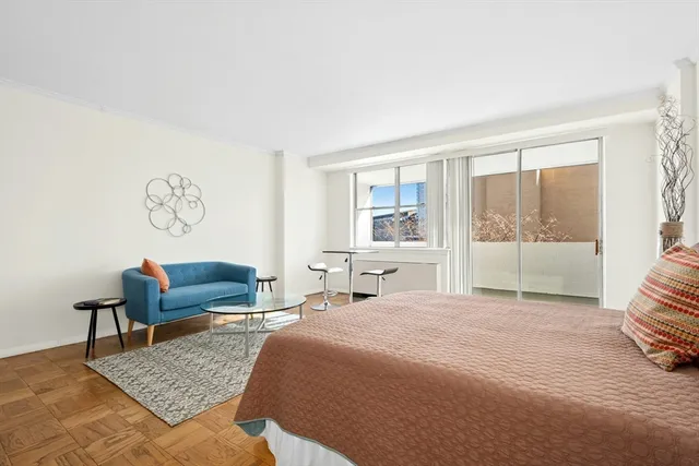 a bedroom with a bed a couch and a window with outer view