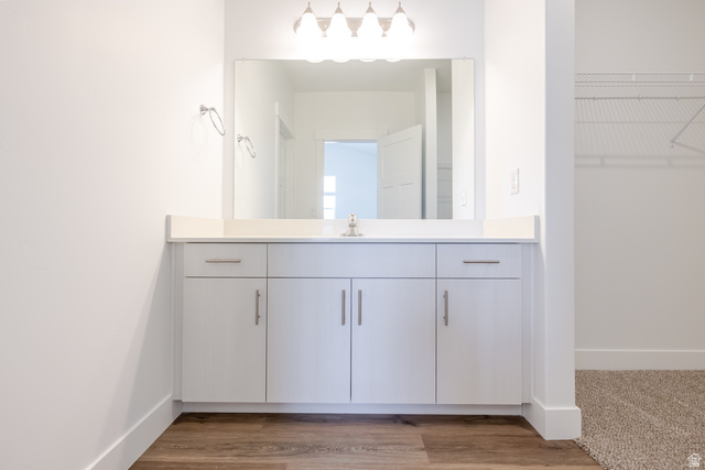 675 West 4500th South, Unit P301 Mapleton, UT 84664 - Photo 9 of 16 Modern vanity with white cabinetry, a light countertop, and a large mirror with overhead lighting