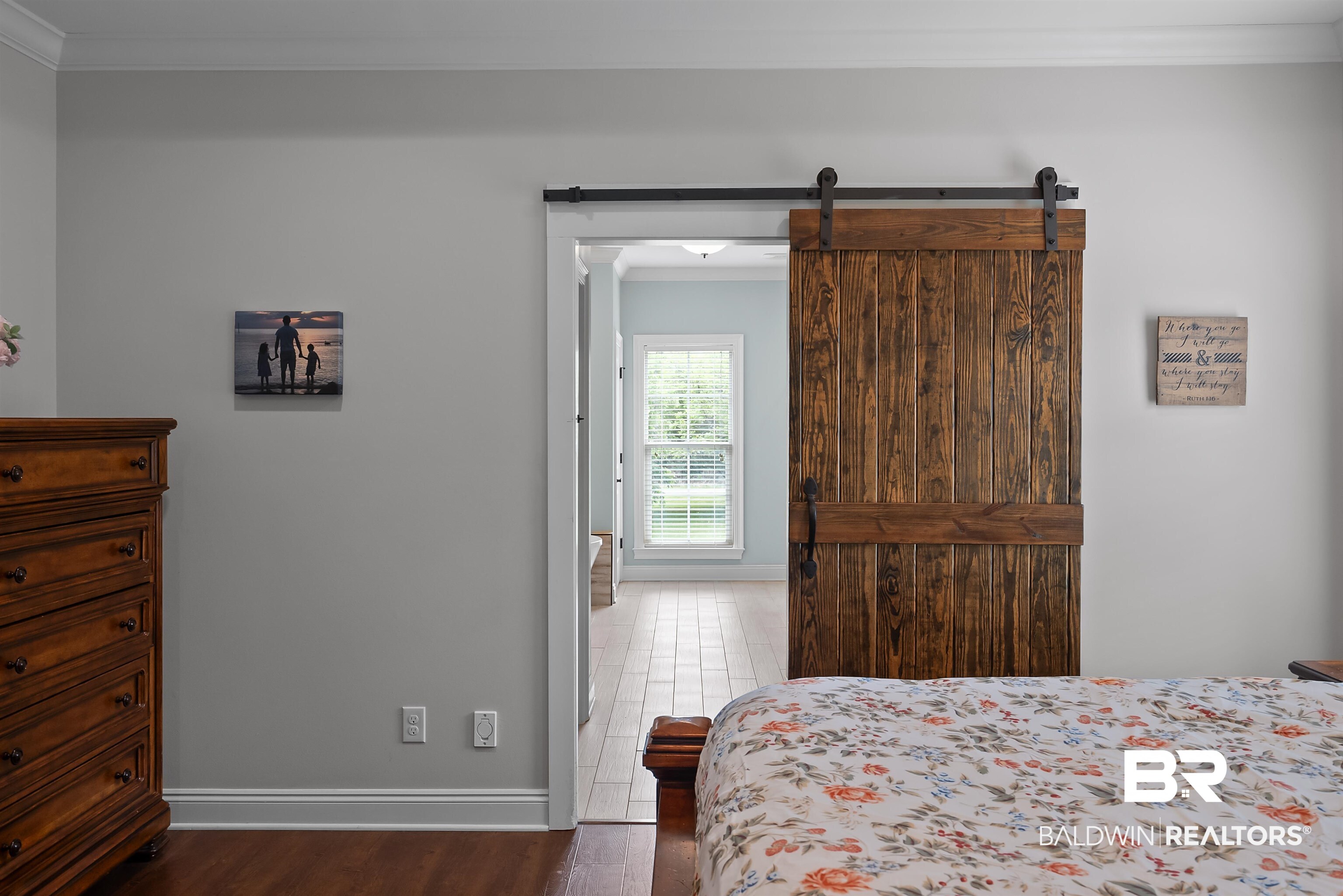 12070 Comalander Road Fairhope, AL 36532 - Photo 21 of 50 Wood-finish flooring throughout, featuring a natural wood barn door with black iron hardware