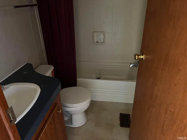 a bathroom with a granite countertop toilet and sink