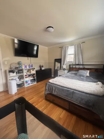 a spacious bedroom with a bed and a flat screen tv