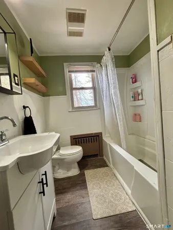a bathroom with a sink a toilet and shower